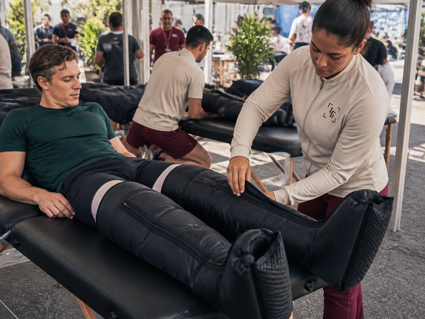 Atleta recebendo recuperação esportiva com botas de compressão